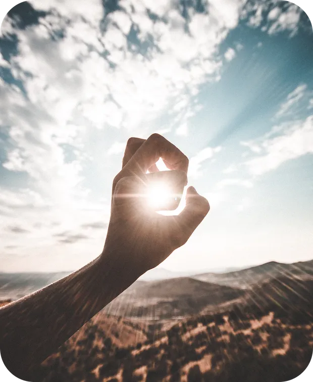 Hand die mit den Fingern eine Sonne rahmt